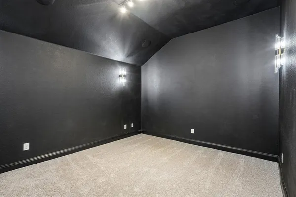 an empty room with windows and ceiling fan