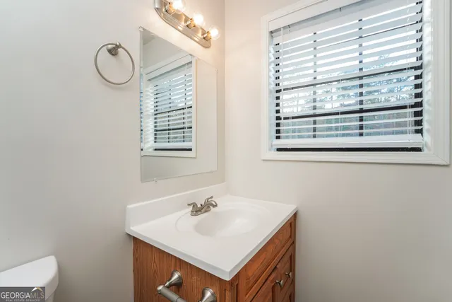 a bathroom with a sink a mirror and a window