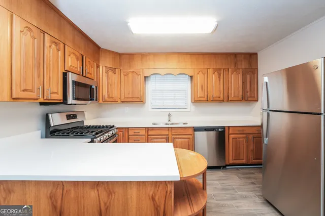 a kitchen with stainless steel appliances granite countertop a refrigerator a stove top oven a sink and dishwasher