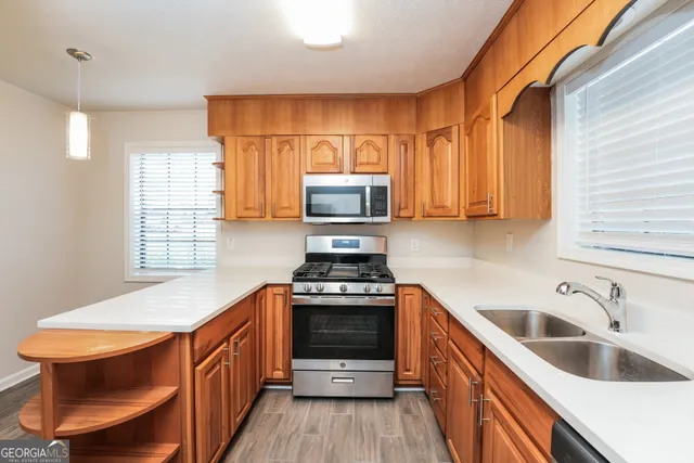 a kitchen with stainless steel appliances a stove a sink and a microwave