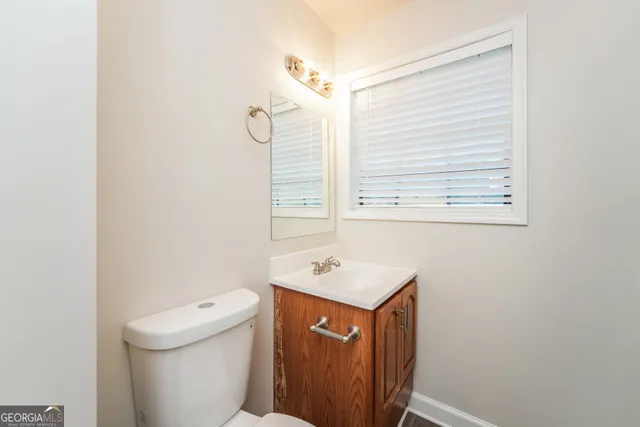 a bathroom with a sink a toilet and a mirror
