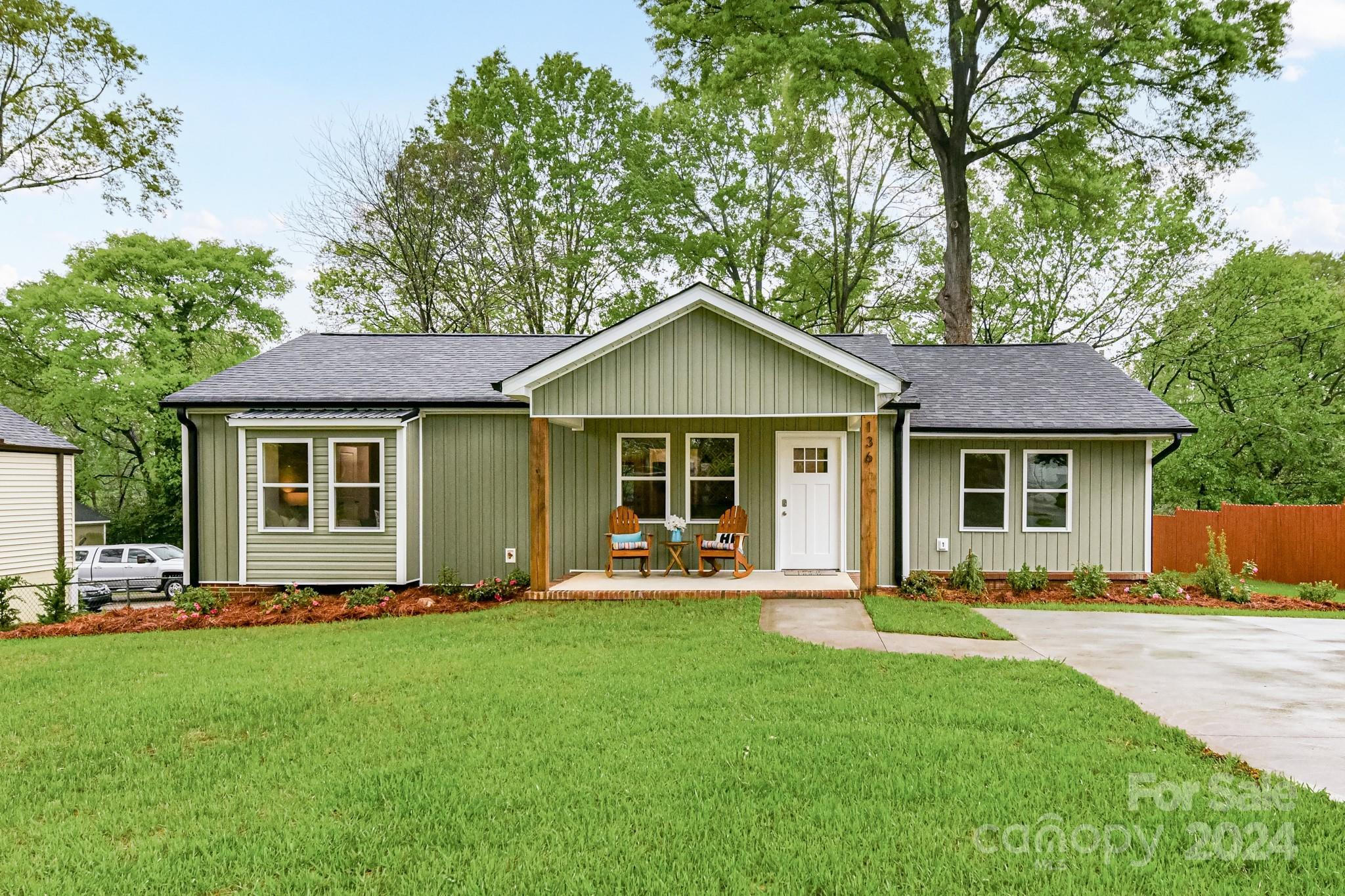a front view of a house with a yard and trees