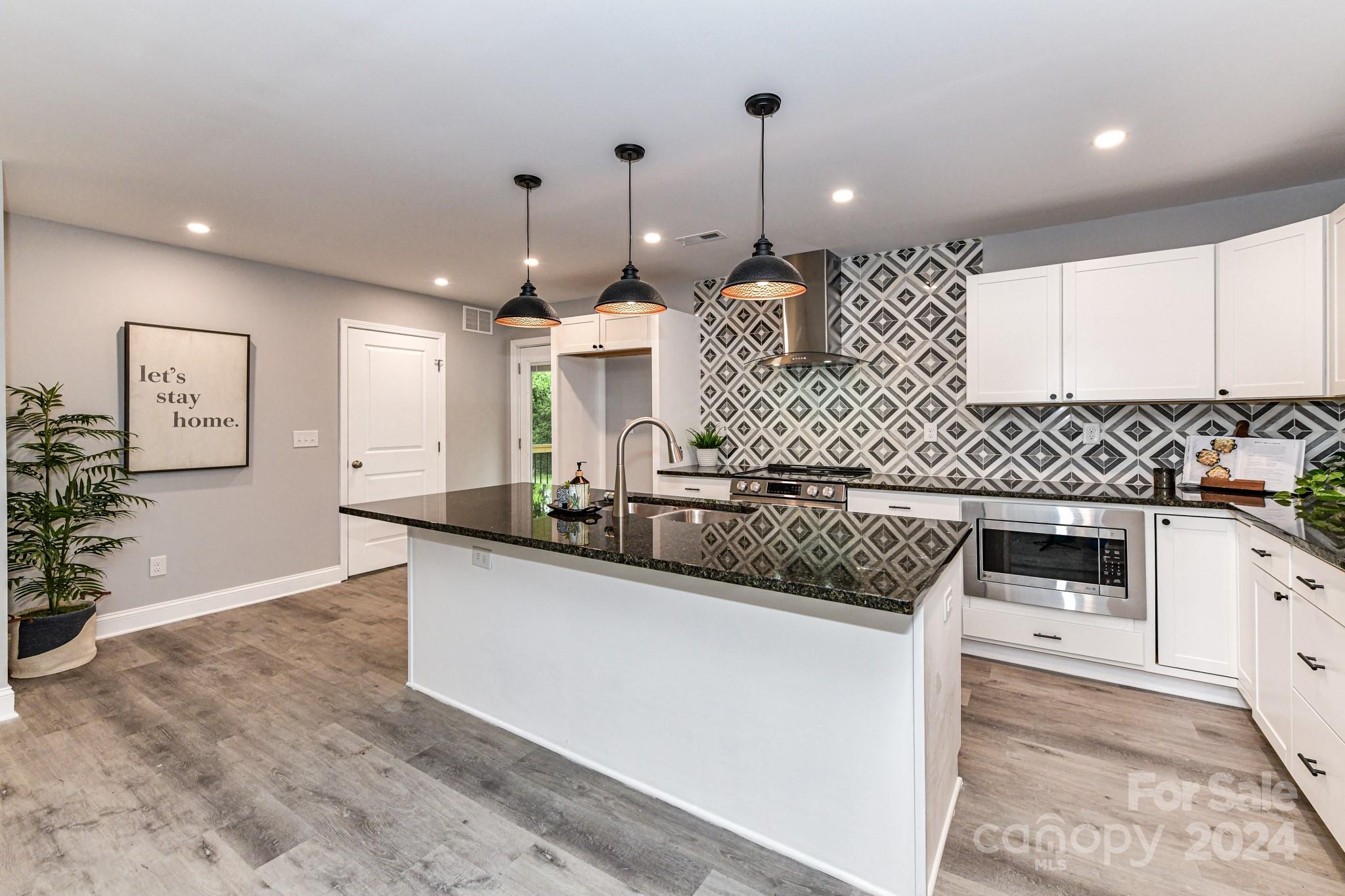 136 Spencer Avenue Northwest Concord, NC 28025 - Photo 13 of 43 a kitchen with stainless steel appliances kitchen island granite countertop a sink a stove and cabinets