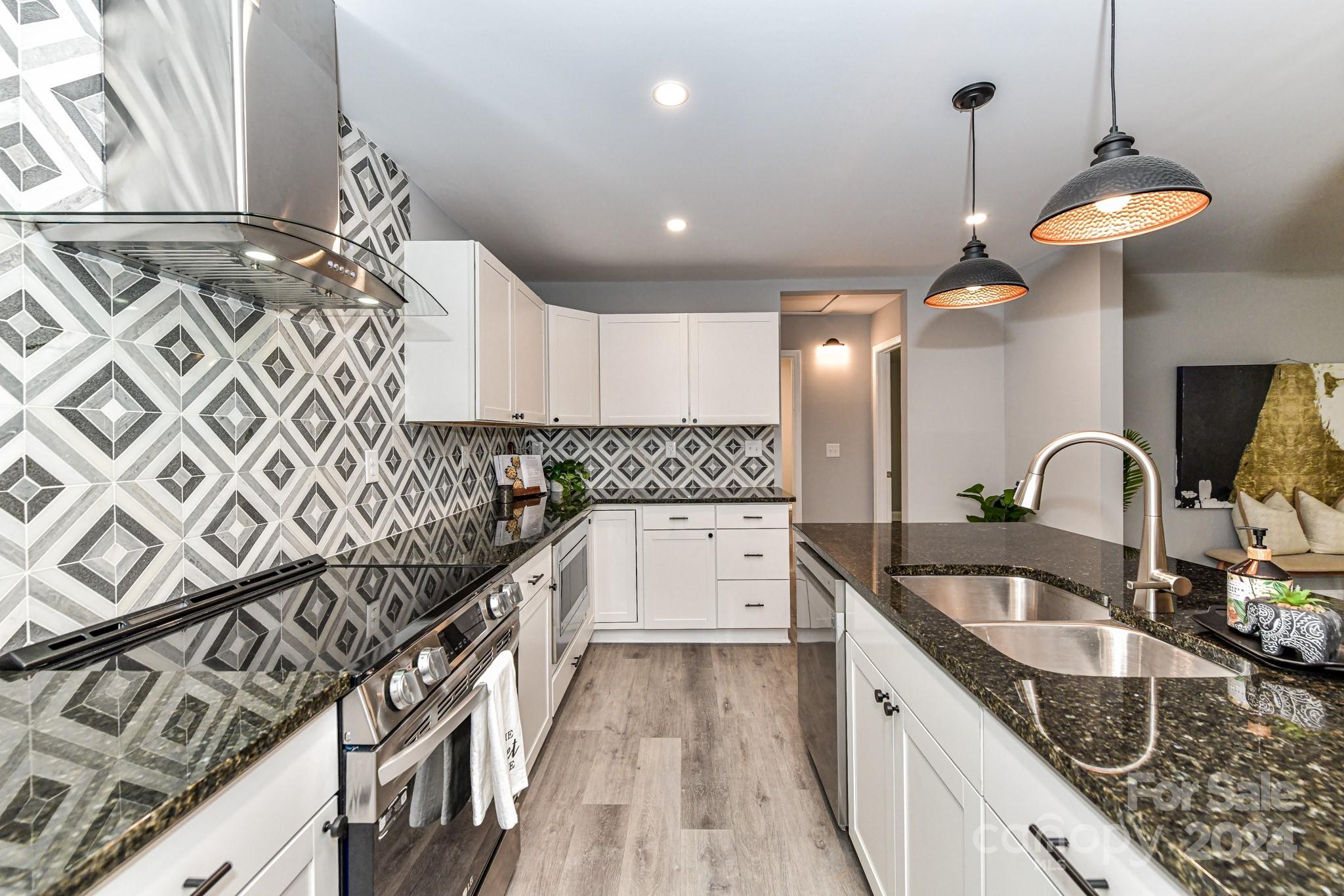 136 Spencer Avenue Northwest Concord, NC 28025 - Photo 14 of 43 a kitchen with granite countertop a sink and a stove top oven