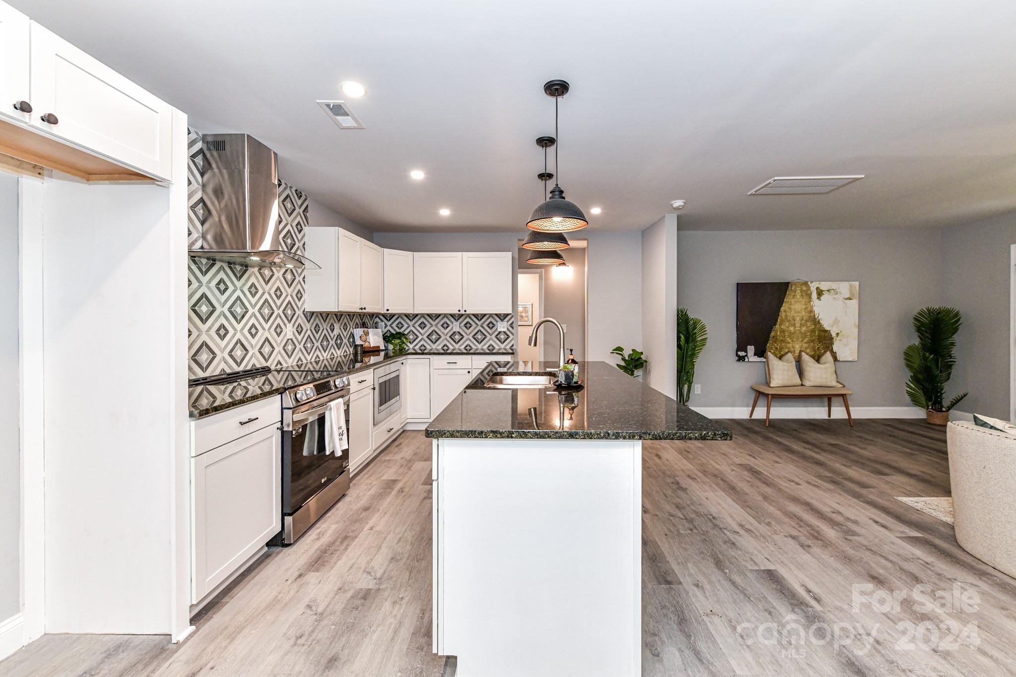 136 Spencer Avenue Northwest Concord, NC 28025 - Photo 16 of 43 a large kitchen with stainless steel appliances kitchen island granite countertop a sink and cabinets