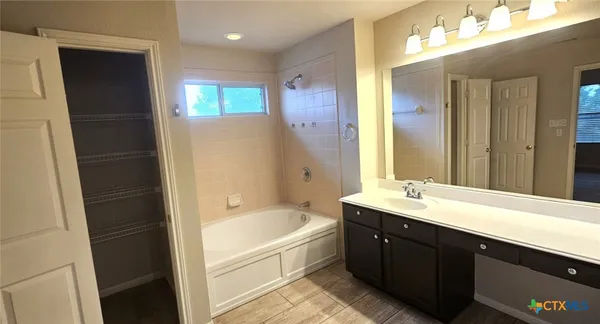 a spacious bathroom with a bathtub sink and mirror