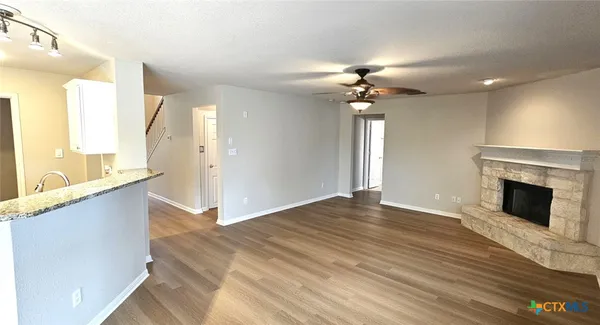 a view of an empty room with a fireplace and a window
