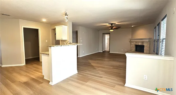 a view of a kitchen with a sink a refrigerator and a fireplace