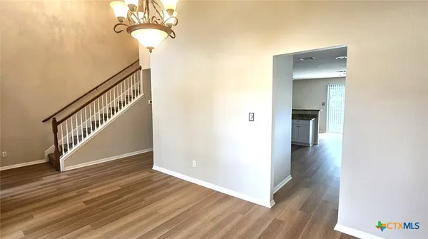 a view of a hallway with wooden floor and staircase