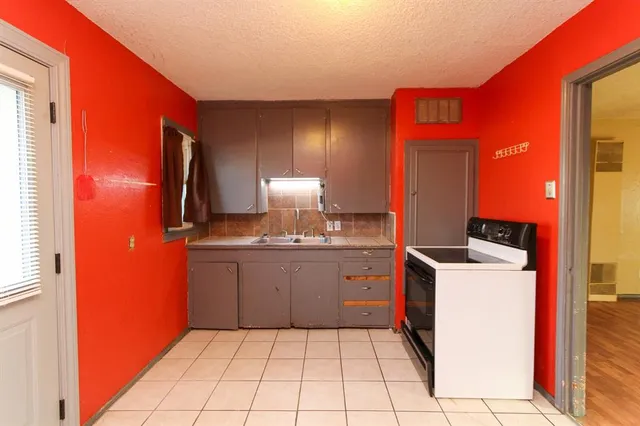 a kitchen with a sink a stove and cabinets