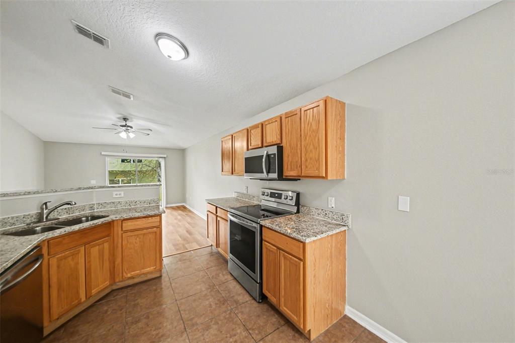 2212 Nicollett Way Leesburg, FL 34748 - Photo 11 of 26 a kitchen with stainless steel appliances granite countertop a sink stove and cabinets