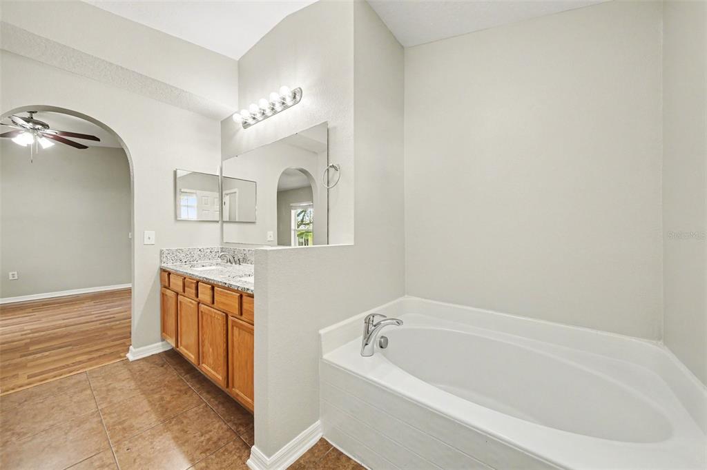 2212 Nicollett Way Leesburg, FL 34748 - Photo 19 of 26 a bathroom with a tub sink and mirror