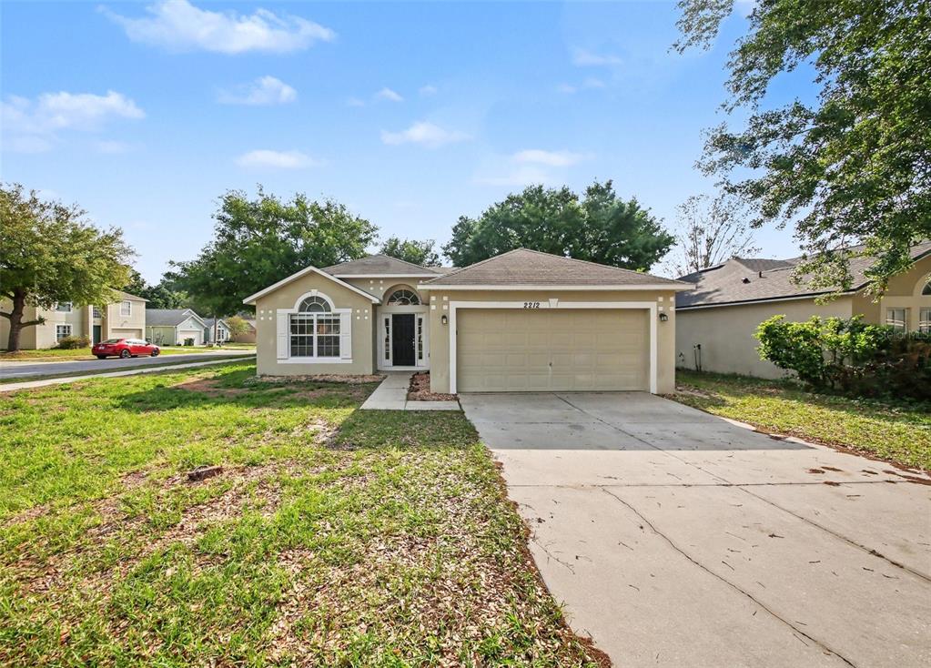 2212 Nicollett Way Leesburg, FL 34748 - Photo 2 of 26 a front view of a house with a yard and garage