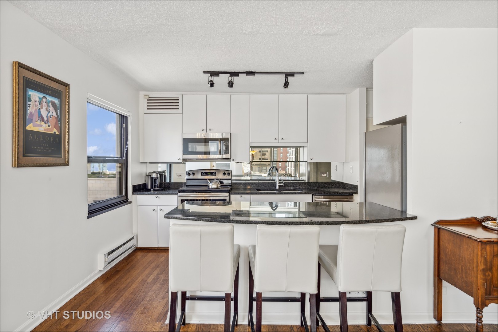 1313 North Ritchie Court, Unit 1304 Chicago, IL 60610 - Photo 8 of 20 a kitchen with stainless steel appliances granite countertop a table chairs sink and cabinets