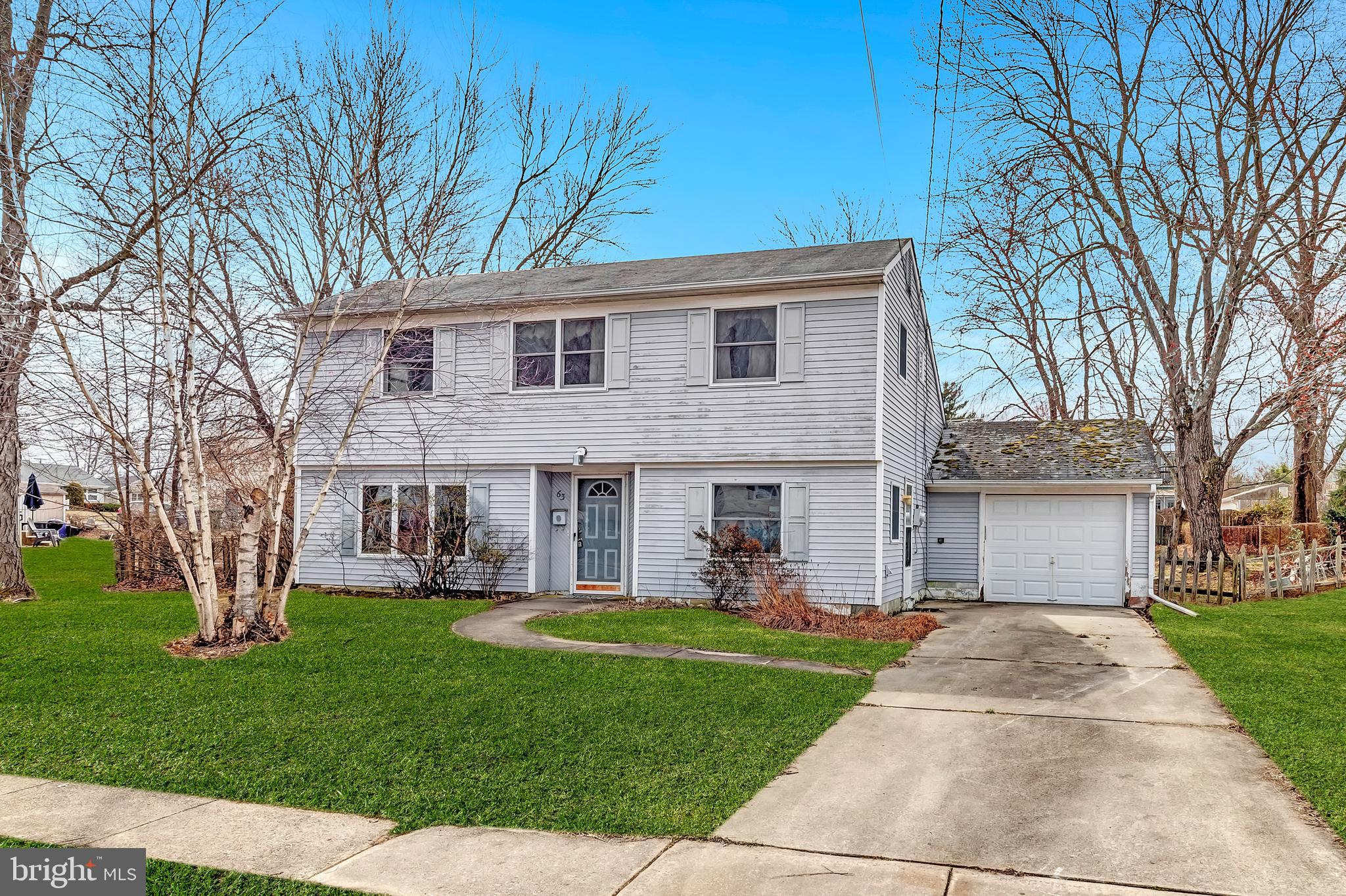 63 Baker Boulevard Marlton, NJ 08053 - Photo 4 of 10 a front view of a house with a garden and trees