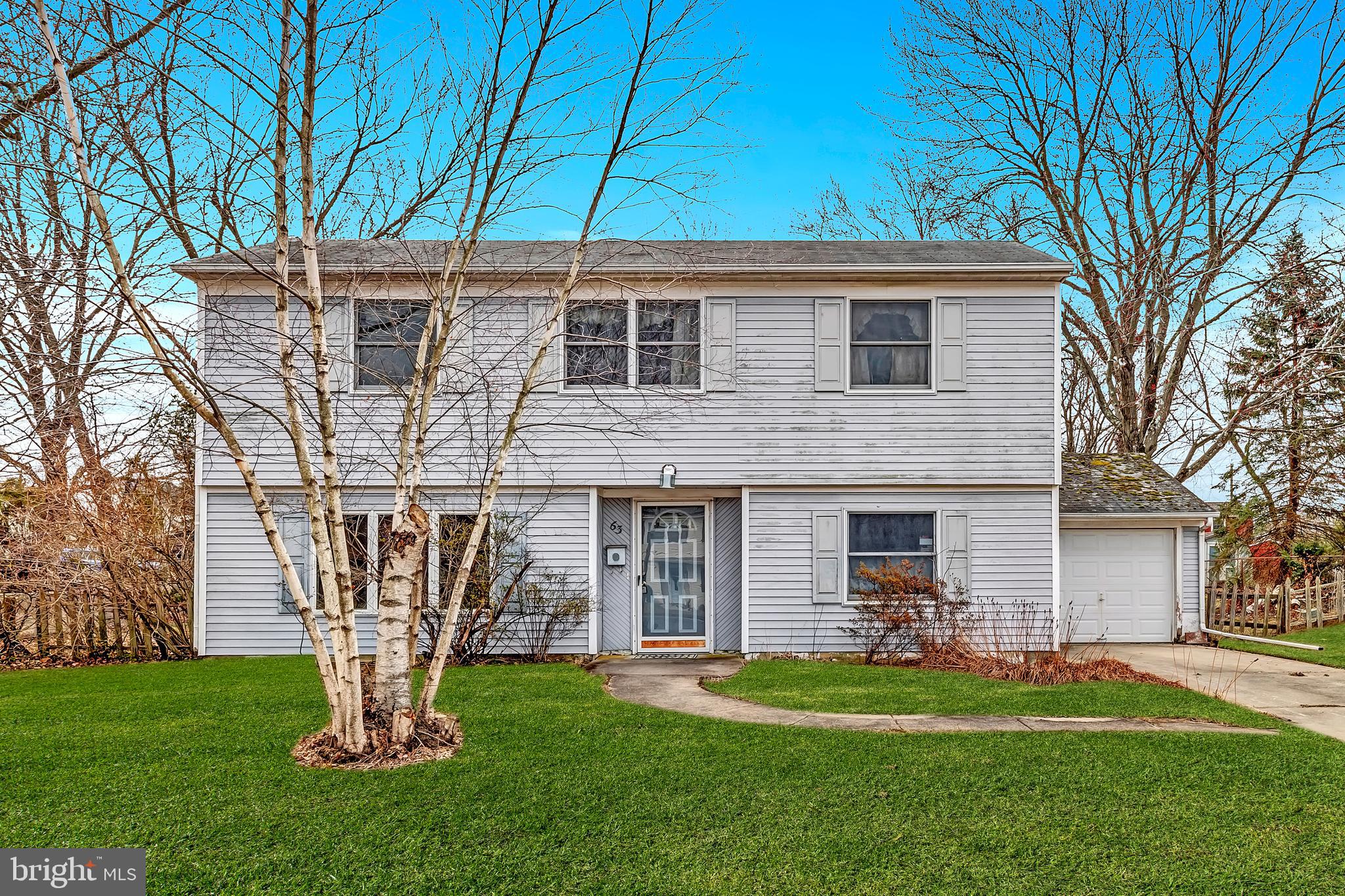 63 Baker Boulevard Marlton, NJ 08053 - Photo 6 of 10 a front view of a house with a garden and trees