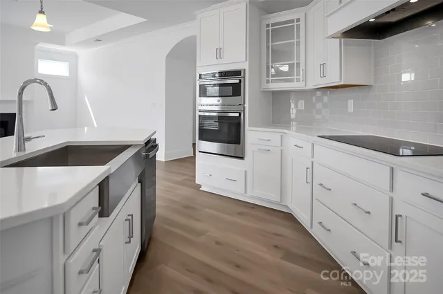 a kitchen with granite countertop white cabinets and stainless steel appliances