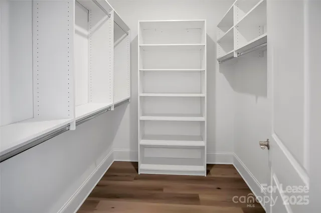 a view of walk in closet with empty racks