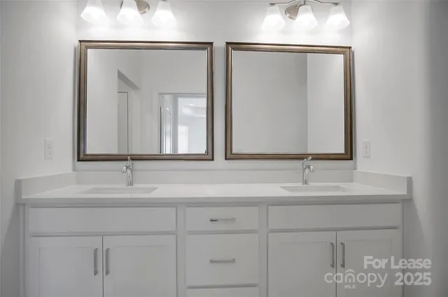 a bathroom with double vanity sink and a mirror