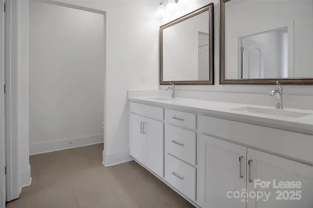 a bathroom with a double vanity sink and mirror