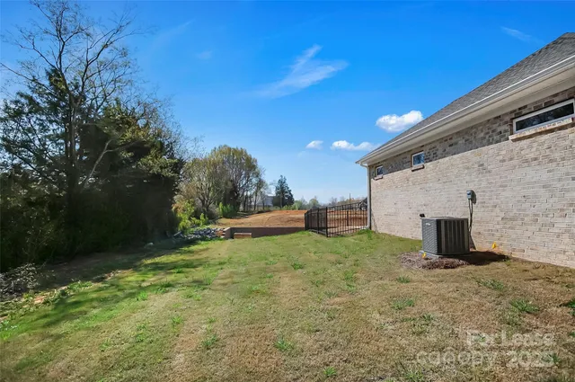 a view of a backyard with plants and large tree