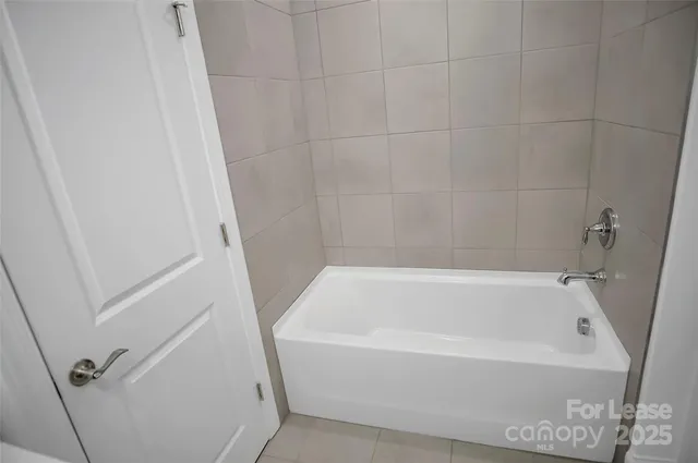 a white bath tub sitting next to a white sink and vanity