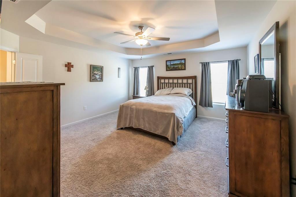 1182 Westhampton Way Villa Rica, GA 30180 - Photo 18 of 26 a bedroom with a large bed and a chandelier