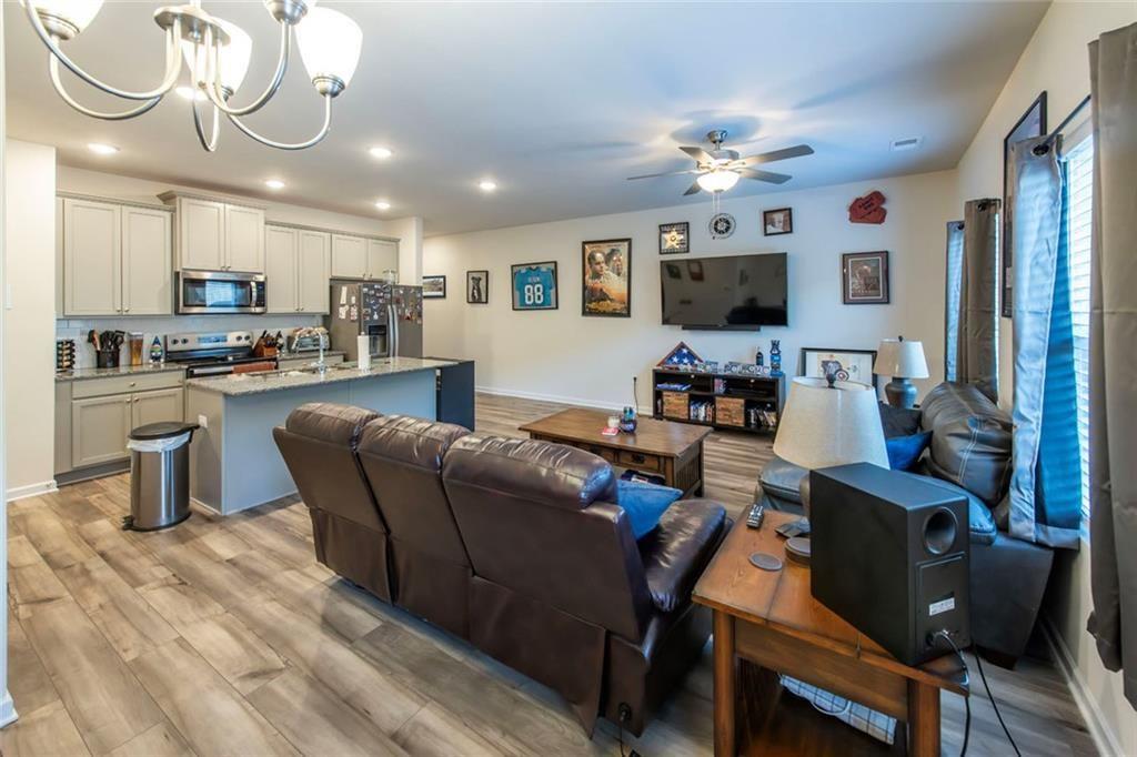 1182 Westhampton Way Villa Rica, GA 30180 - Photo 6 of 26 a living room with furniture a flat screen tv and kitchen view