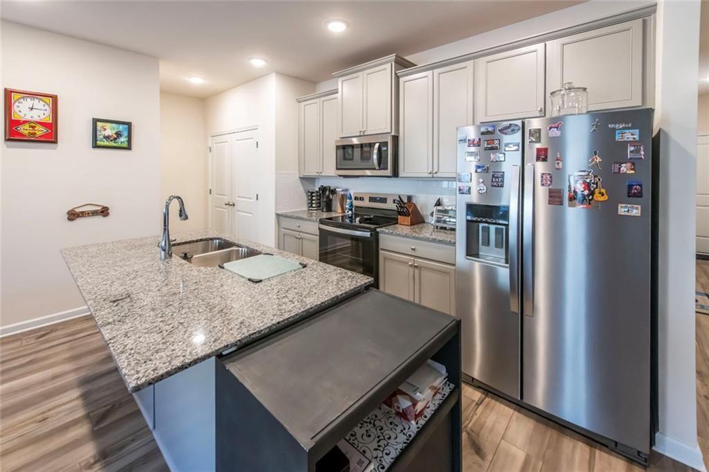 1182 Westhampton Way Villa Rica, GA 30180 - Photo 9 of 26 a kitchen with stainless steel appliances granite countertop a refrigerator a stove and a sink with wooden floor