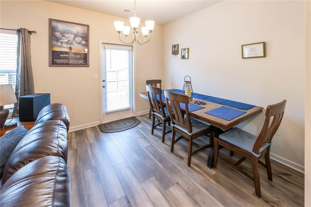 1182 Westhampton Way Villa Rica, GA 30180 - Photo 10 of 26 a view of a dining room with furniture wooden floor and a chandelier