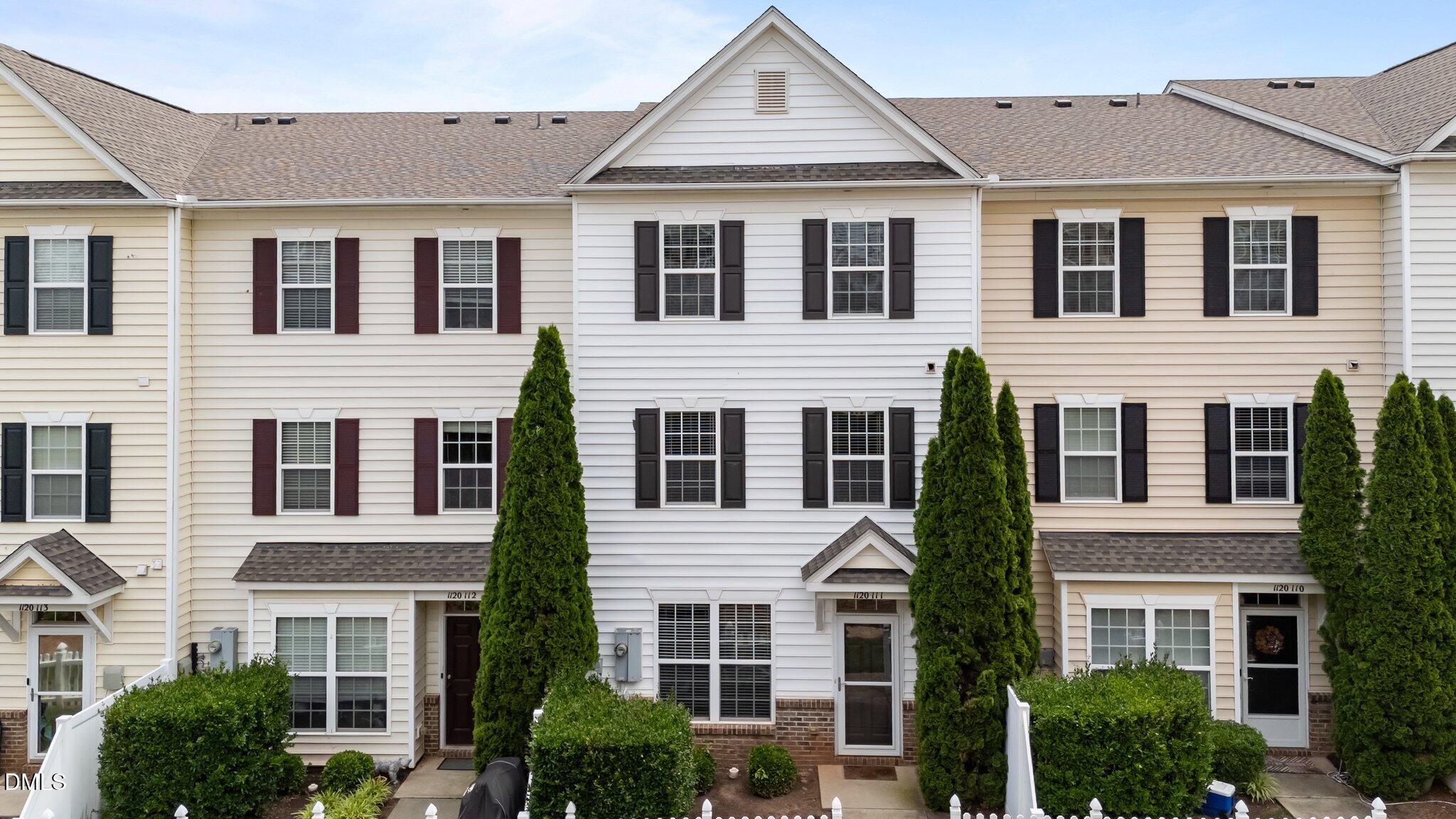 a view of a white house with large windows and a small yard