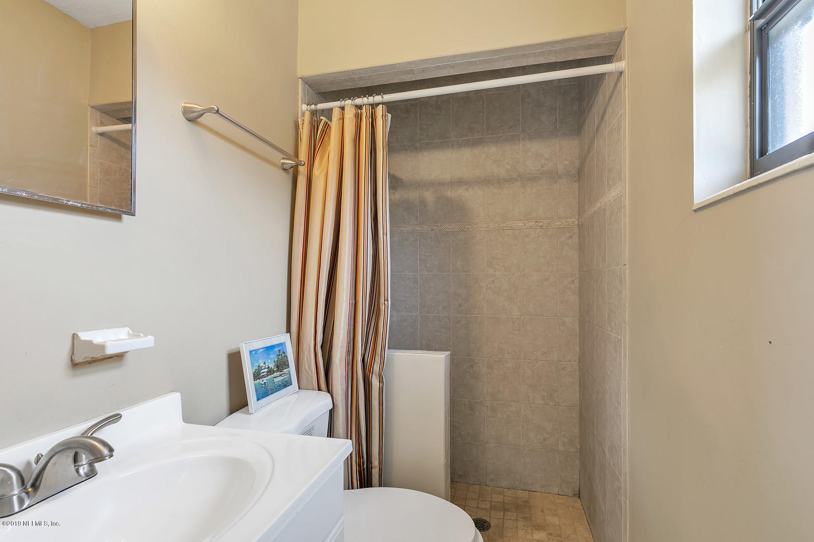 7464 Centauri Road Jacksonville, FL 32210 - Photo 12 of 15 a bathroom with a sink and a mirror