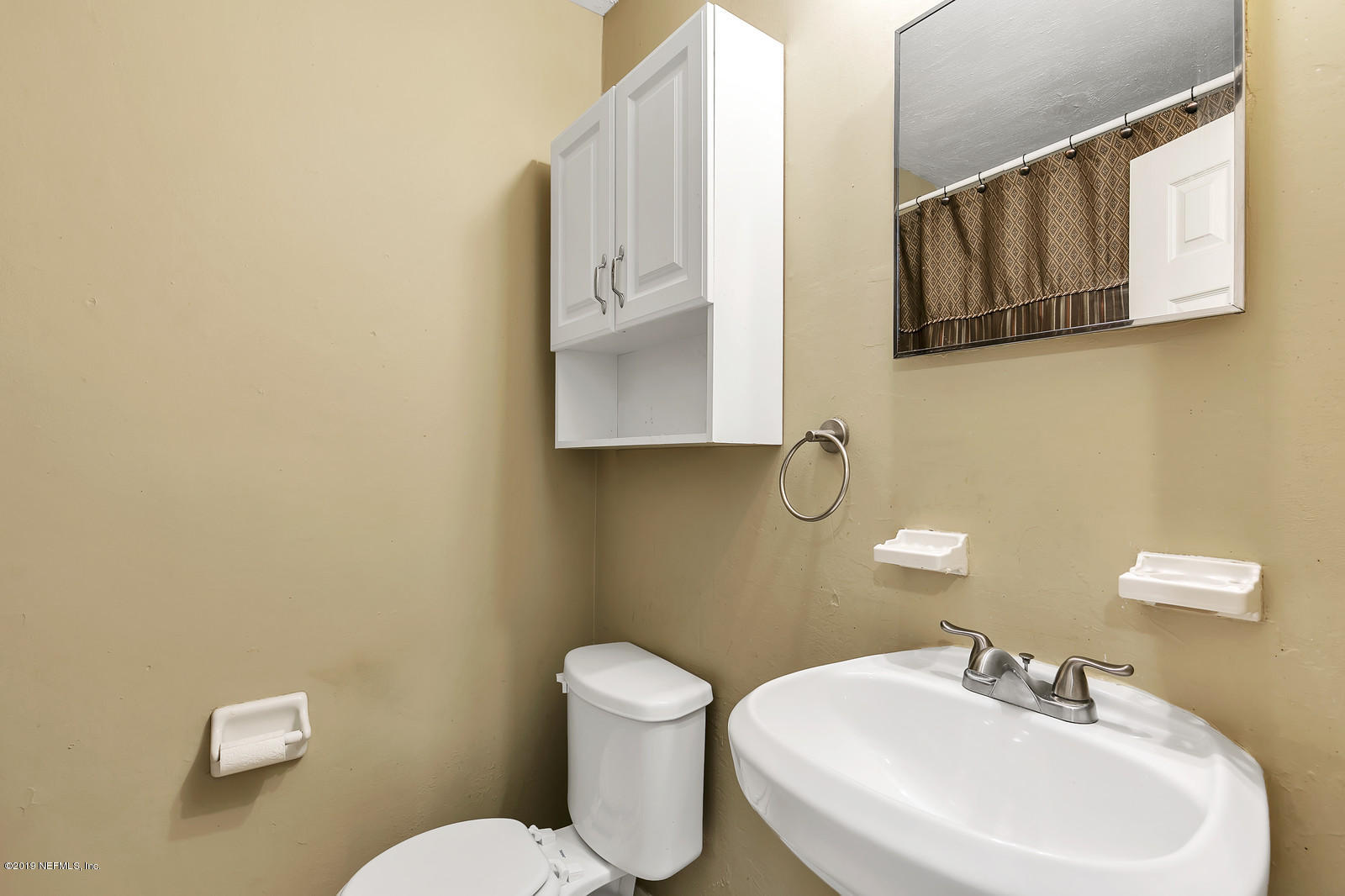 7464 Centauri Road Jacksonville, FL 32210 - Photo 14 of 15 a bathroom with a toilet sink and mirror
