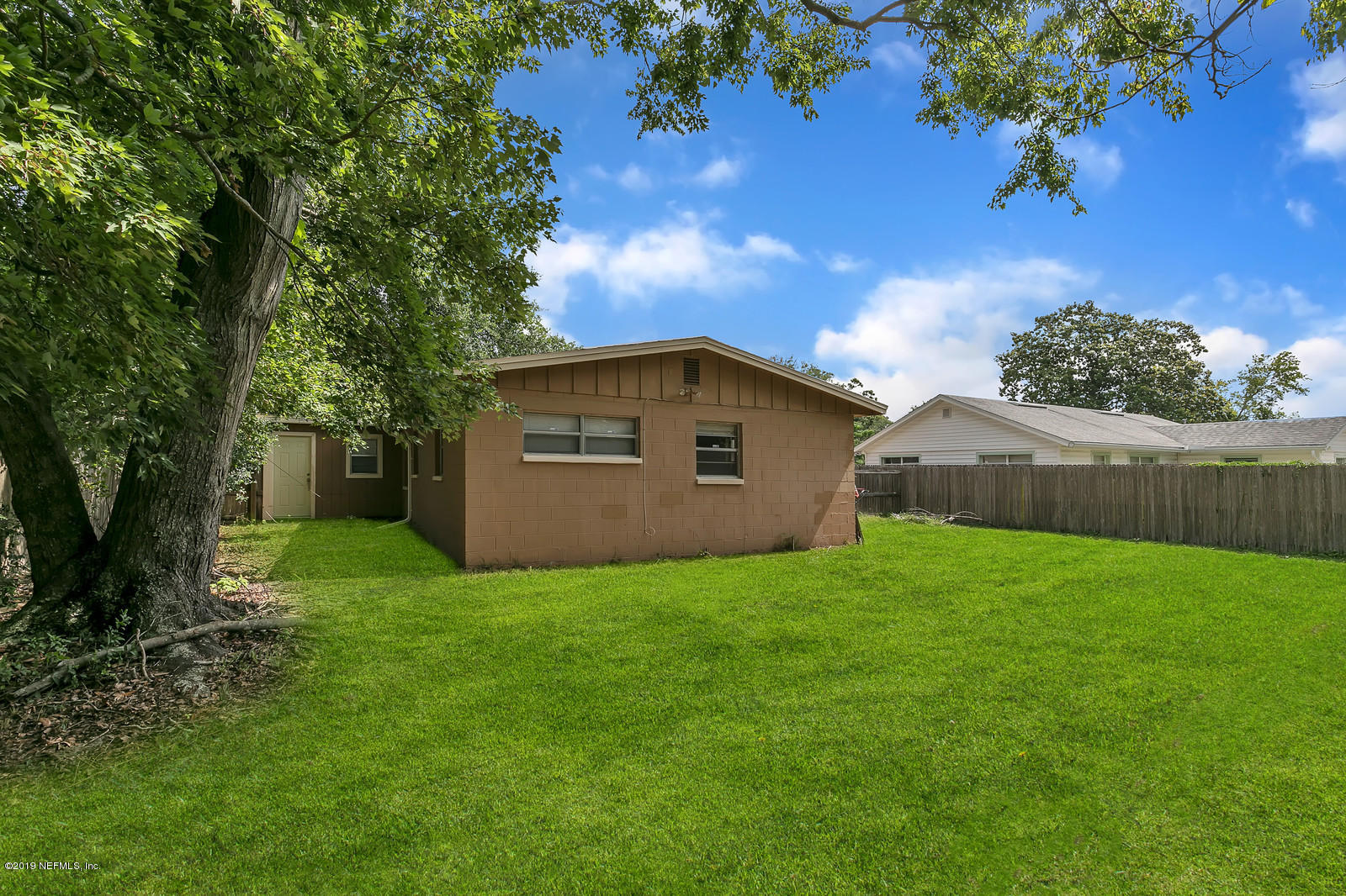 7464 Centauri Road Jacksonville, FL 32210 - Photo 4 of 15 a view of a backyard with potted plants and large tree