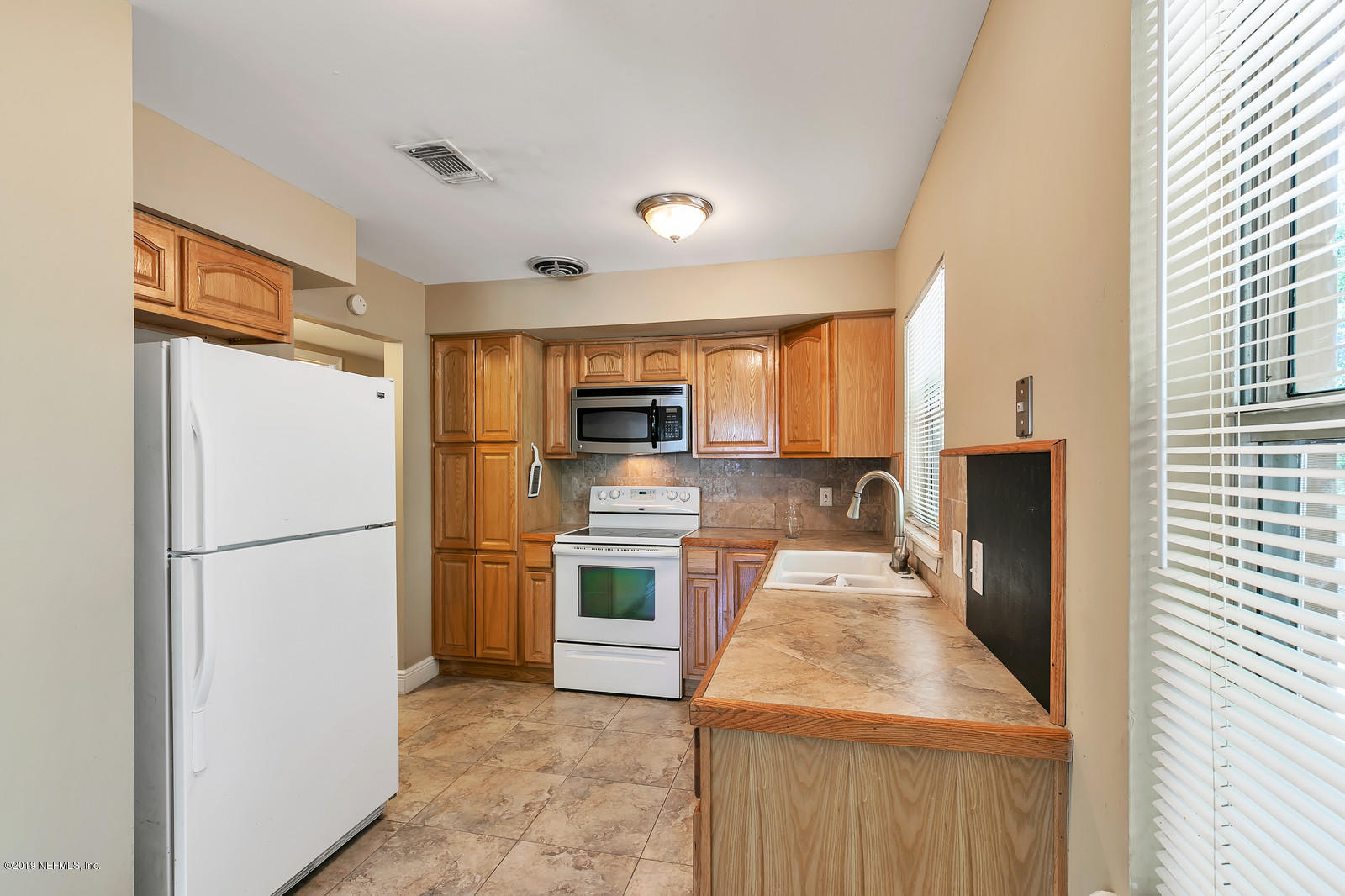 7464 Centauri Road Jacksonville, FL 32210 - Photo 7 of 15 a kitchen with a refrigerator a stove top oven and a sink