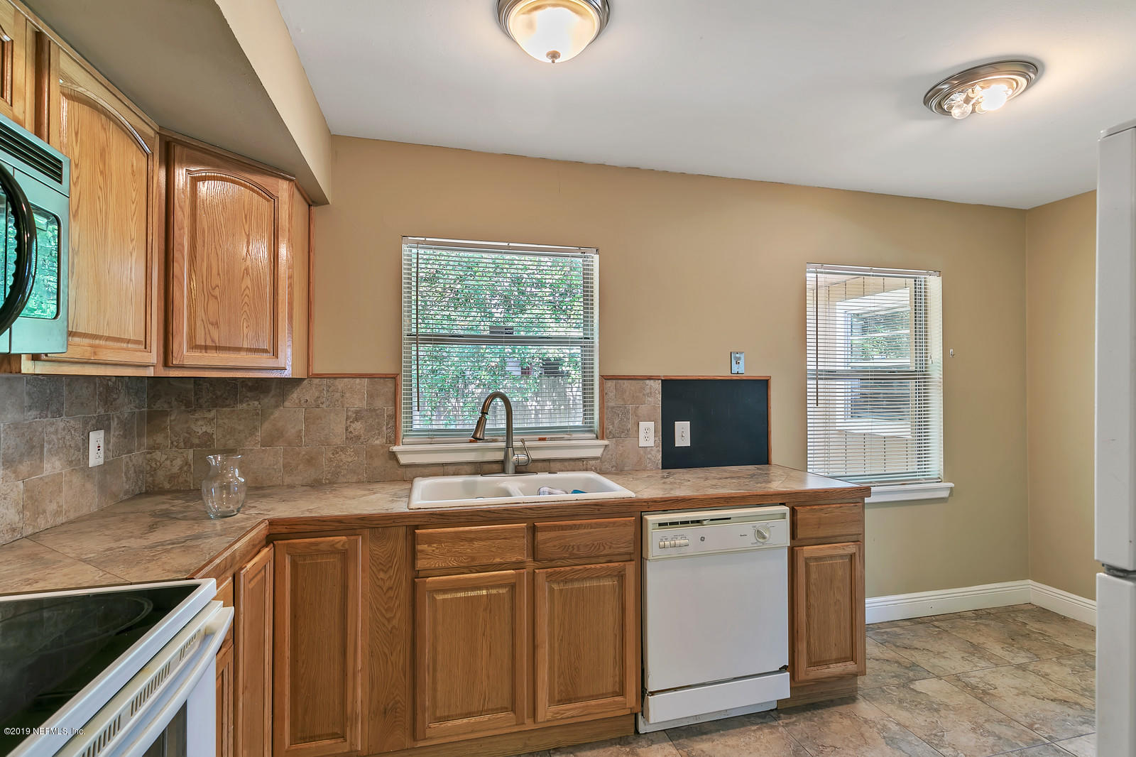 7464 Centauri Road Jacksonville, FL 32210 - Photo 8 of 15 a kitchen with stainless steel appliances granite countertop a sink a stove and a microwave oven