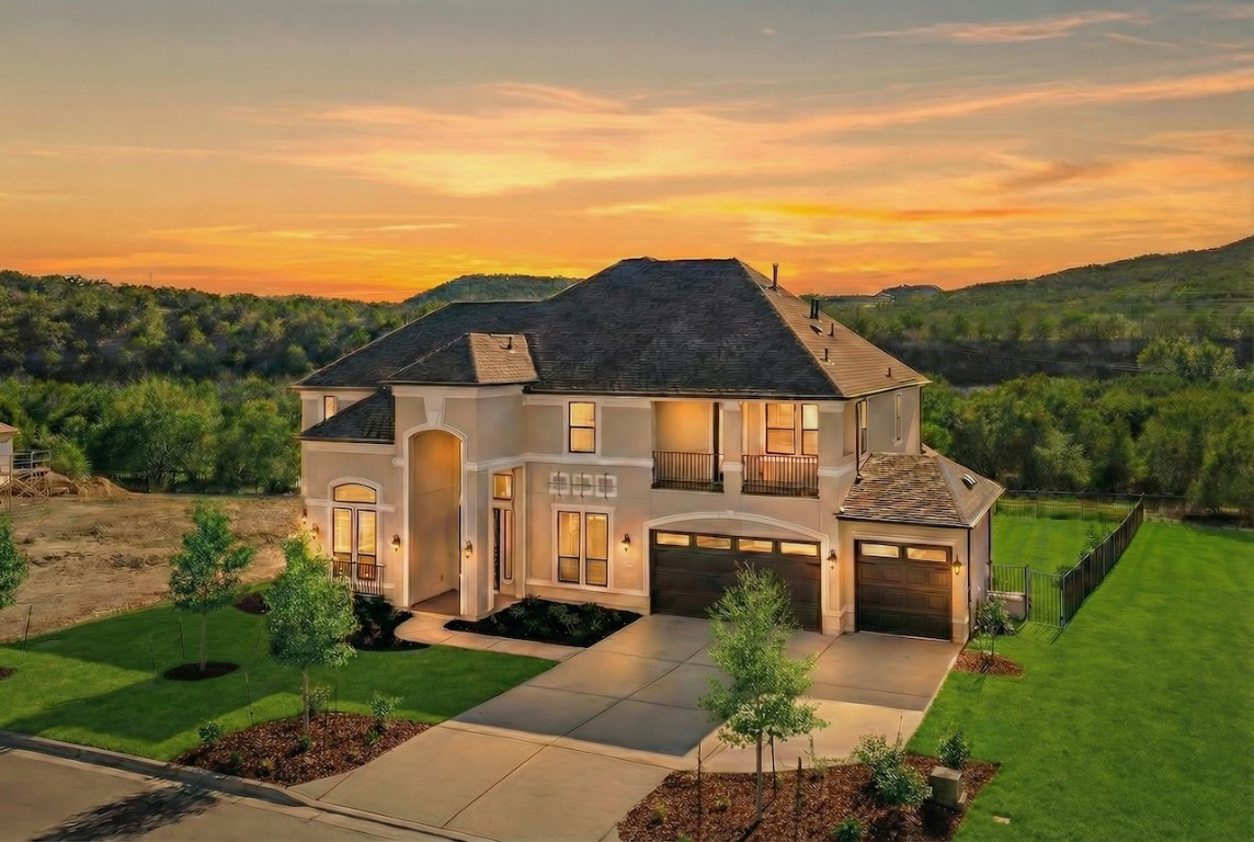 View of front of property featuring a balcony, stucco siding, concrete driveway, and a garage