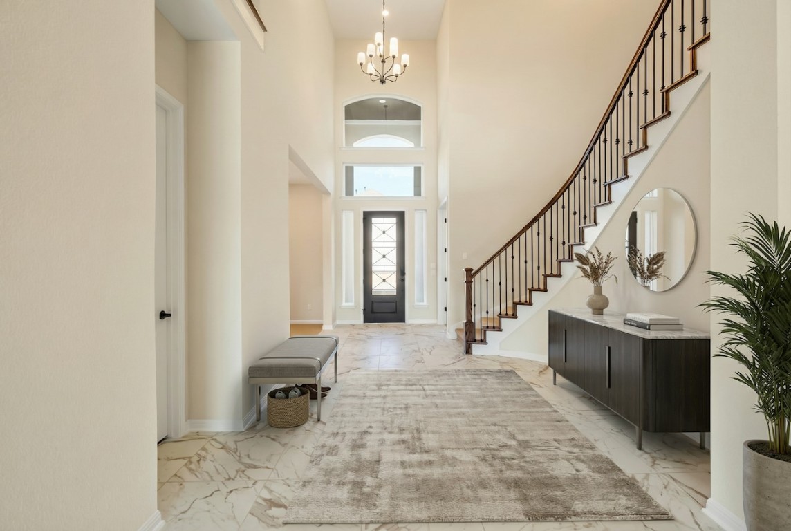 2660 Novara Trail Leander, TX 78641 - Photo 3 of 22 Foyer with light marble finish flooring, a towering ceiling, and a chandelier