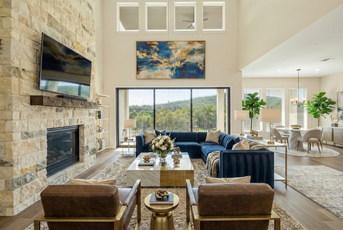 2660 Novara Trail Leander, TX 78641 - Photo 6 of 22 Living room with wood finished floors, a towering ceiling, a stone fireplace, healthy amount of natural light, and a chandelier