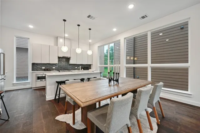 a kitchen with a table chairs a sink dishwasher window and cabinets