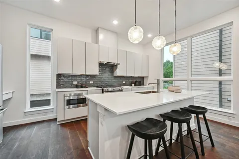a kitchen with a sink cabinets and wooden floor