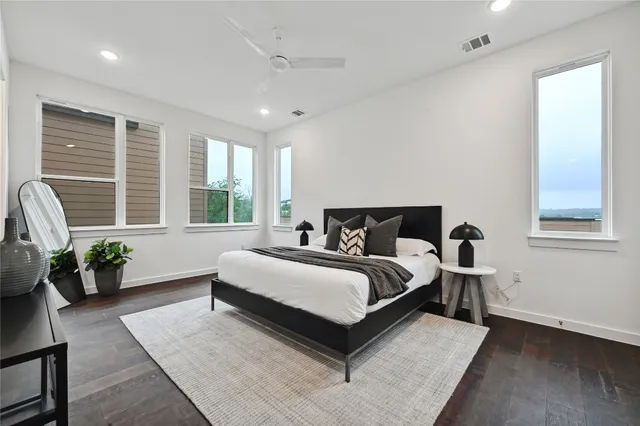 a spacious bedroom with a bed couch and windows