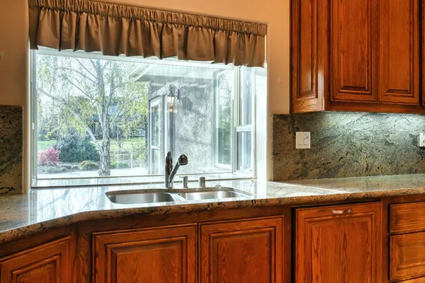 a kitchen with stainless steel appliances granite countertop a sink and cabinets with wooden floor