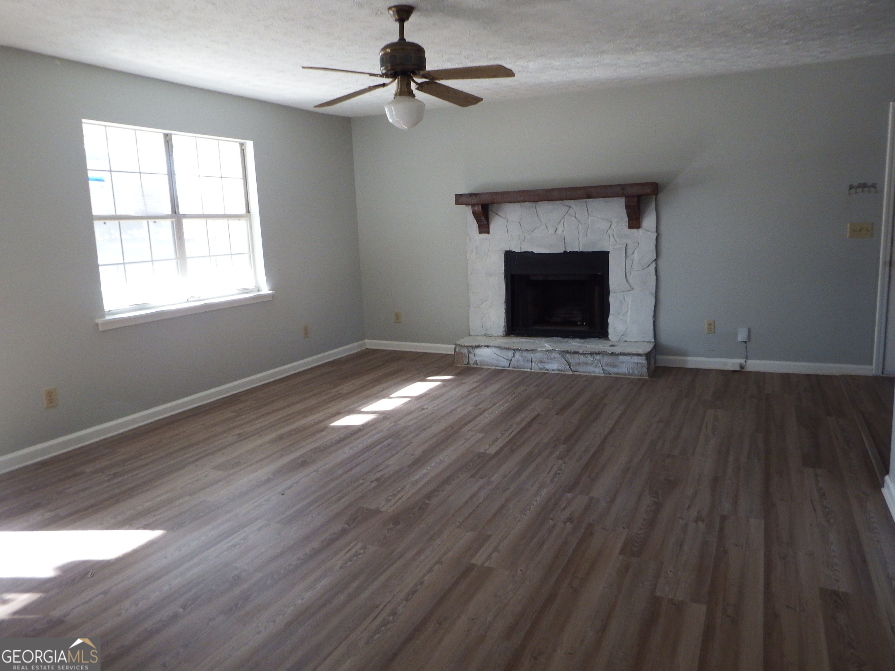 2780 Highpoint Road Snellville, GA 30078 - Photo 4 of 12 wooden floor in an empty room with a fireplace