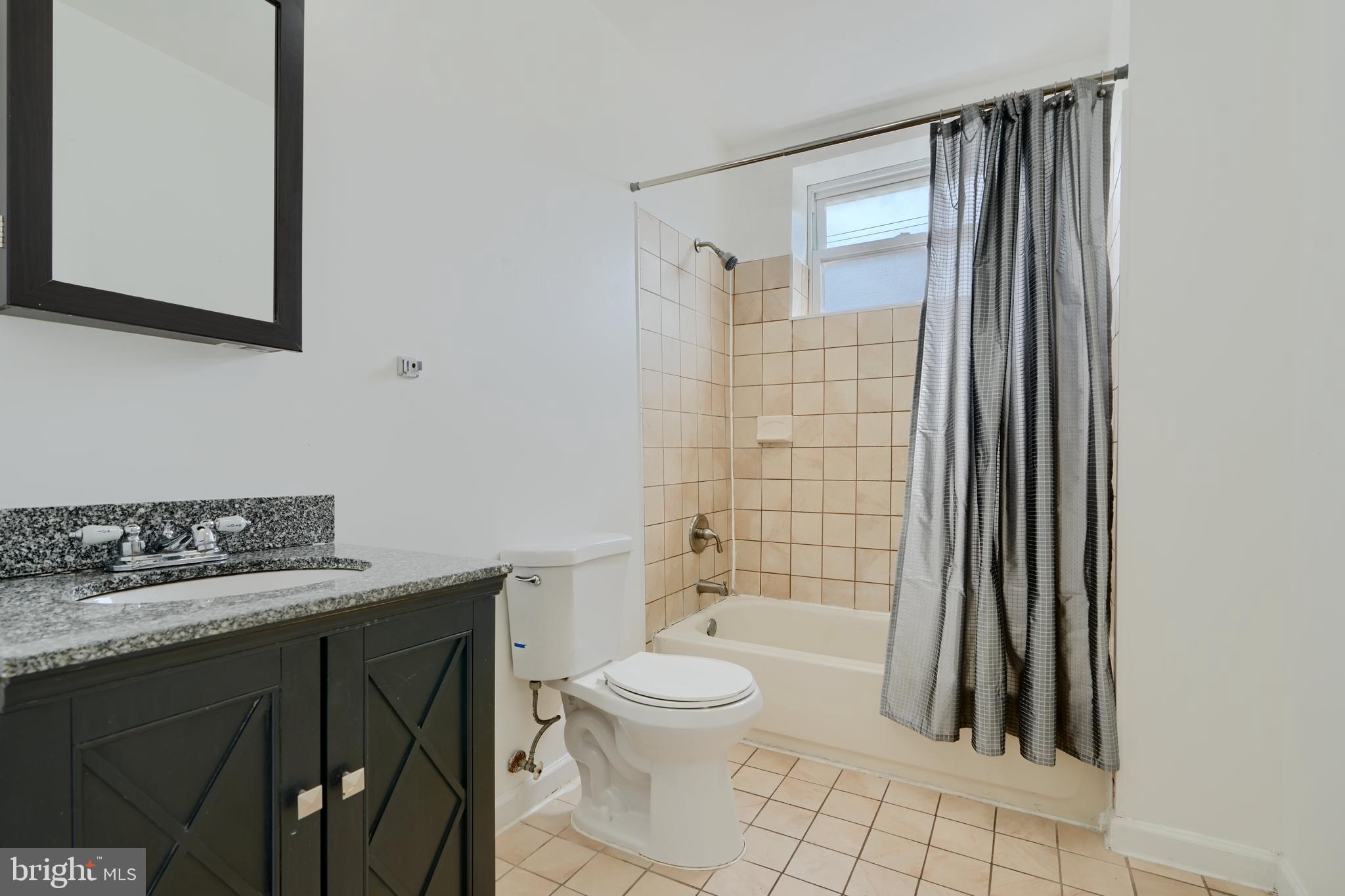2251 Annapolis Road Baltimore, MD 21230 - Photo 10 of 13 a bathroom with a granite countertop sink toilet a mirror and shower