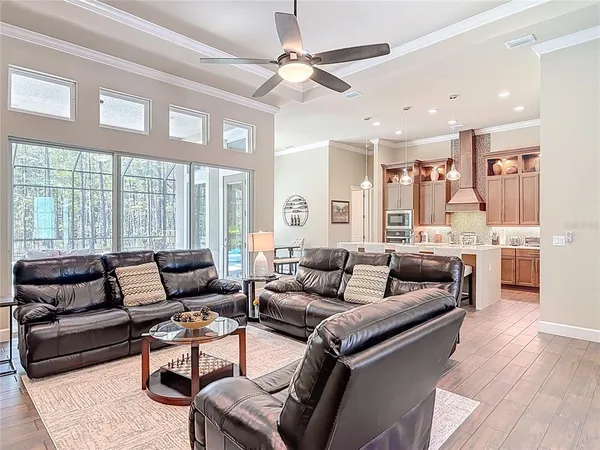 a living room with furniture a flat screen tv and kitchen view