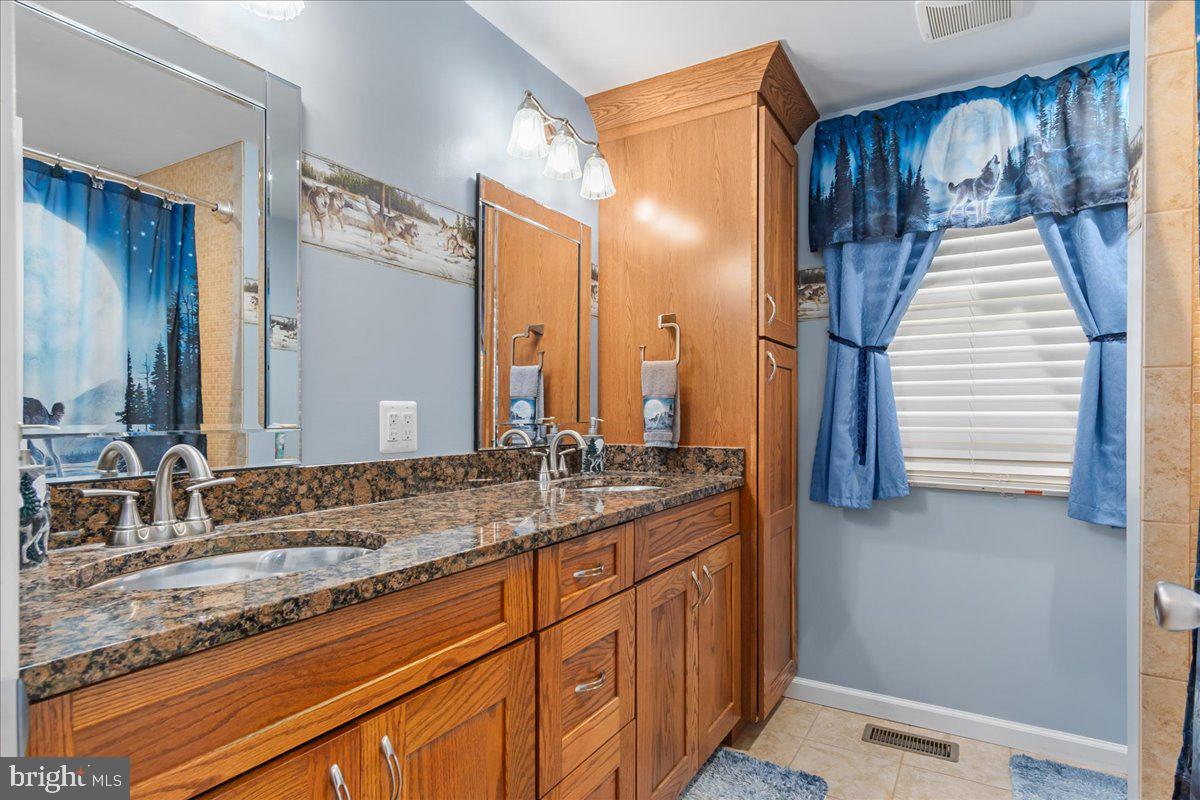 11701 Walnut Point Road Hagerstown, MD 21740 - Photo 27 of 56 a bathroom with a granite countertop sink and a mirror