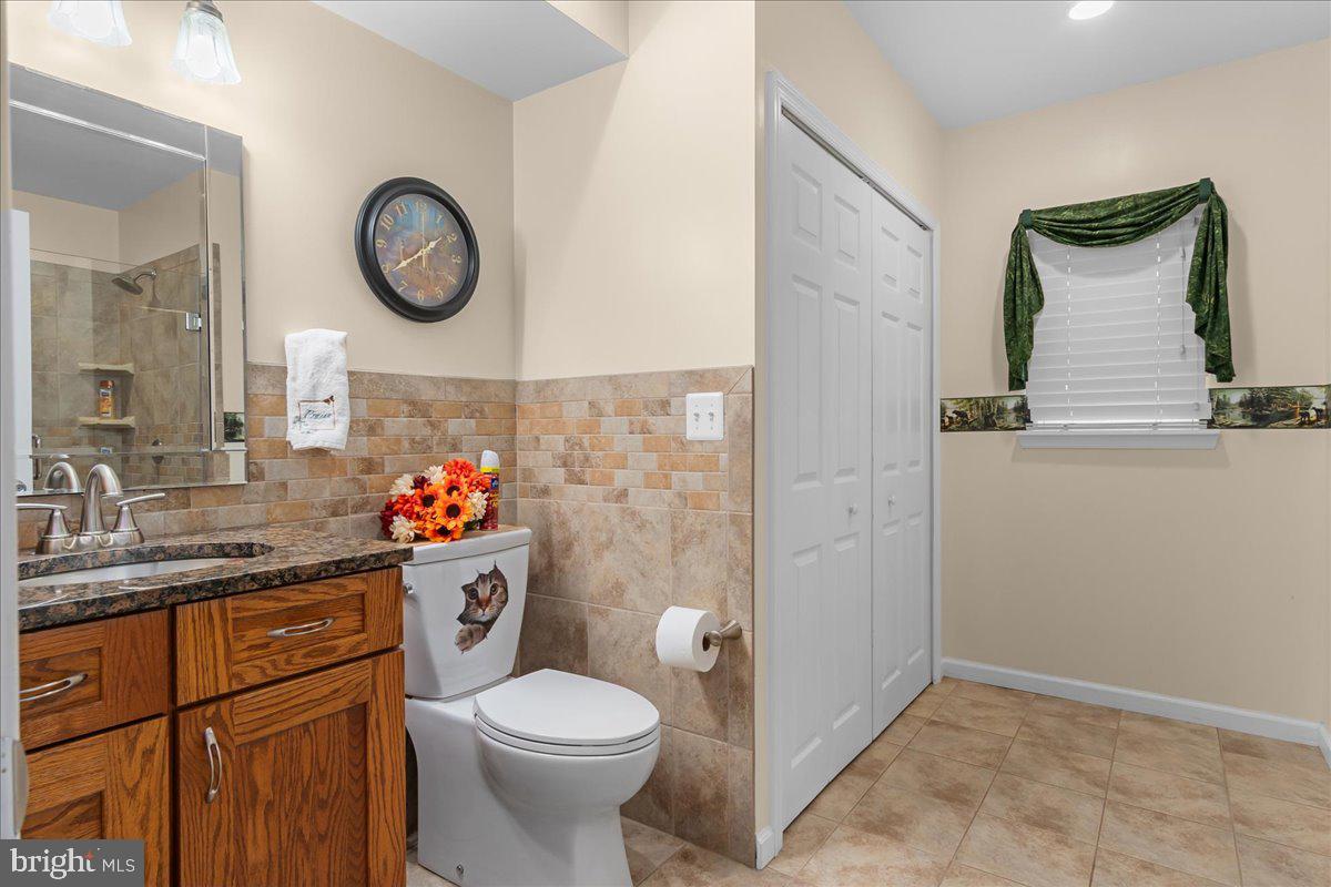 11701 Walnut Point Road Hagerstown, MD 21740 - Photo 35 of 56 a bathroom with a toilet sink vanity and mirror