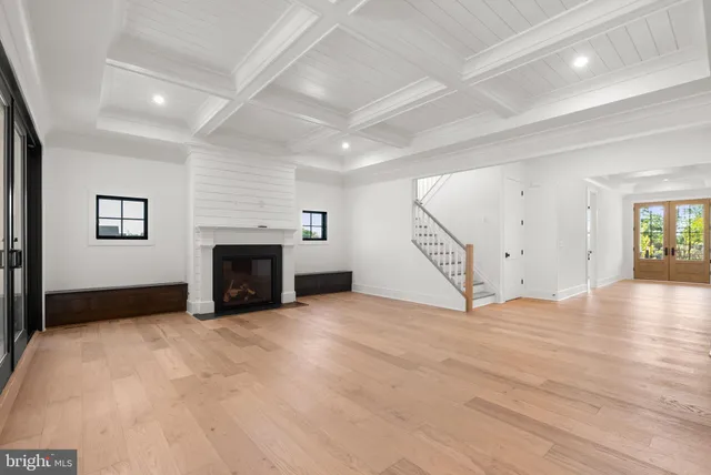 an empty room with windows and fireplace