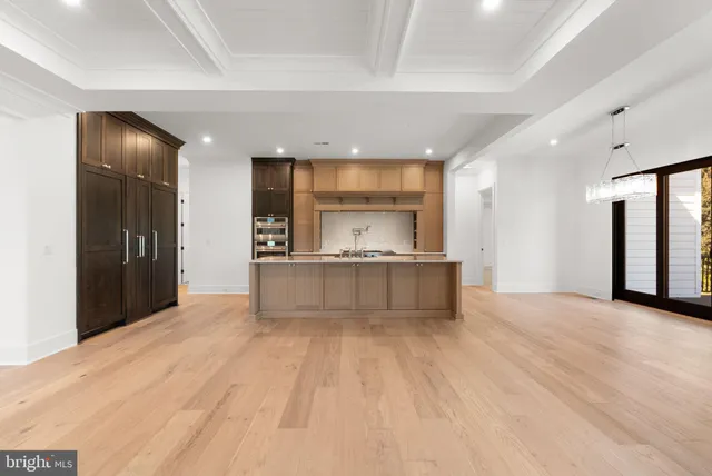 a large kitchen with stainless steel appliances granite countertop a large counter top and a wooden floors